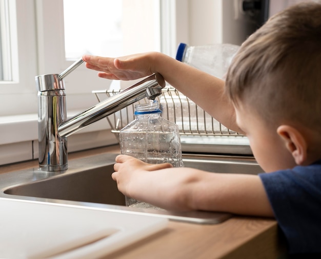 Cerrar la botella de llenado de niño con agua