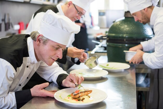 Cerrar el chef decorando el plato después de cocinar