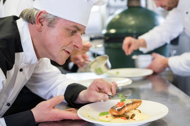 Cerrar el chef decorando el plato después de cocinar