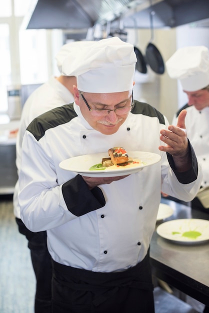 Foto gratuita cerrar el chef oliendo el plato después de cocinar