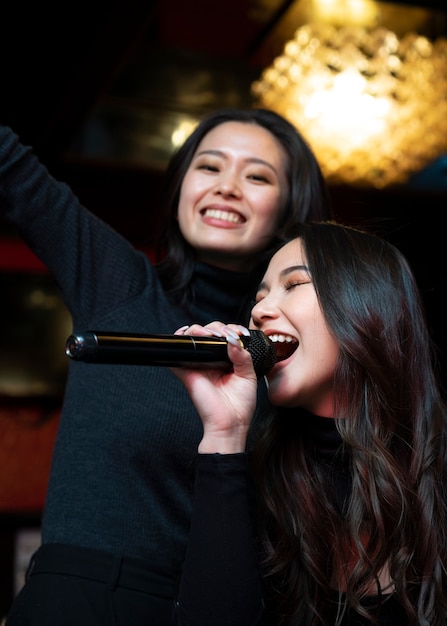 Cerrar chicas sonrientes cantando