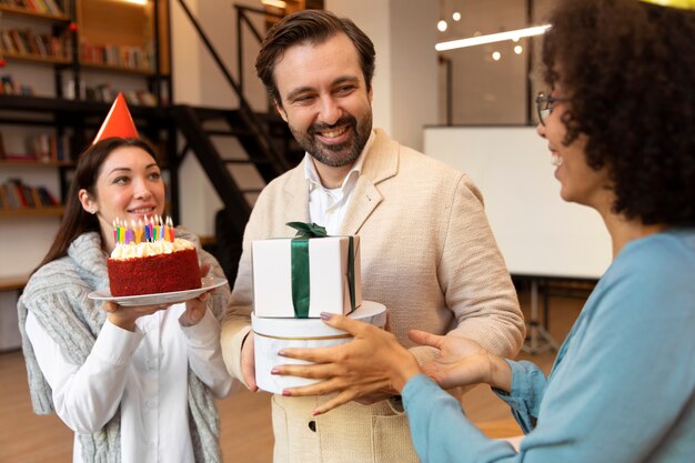 Cerrar colegas celebrando con regalos