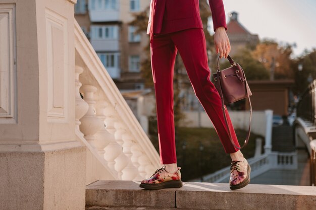 Cerrar detalles de moda de mujer elegante en traje morado caminando en la calle de la ciudad, tendencia de moda de primavera verano otoño temporada con bolso, pantalones y zapatos de moda calzado