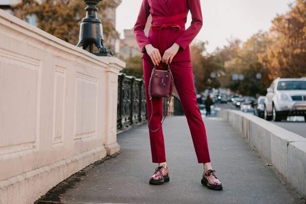 Foto gratuita cerrar detalles de moda de mujer elegante en traje morado caminando en las calles de la ciudad, tendencia de moda primavera verano otoño temporada sosteniendo el bolso