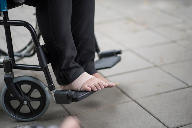 Cerrar el dolor de pies ancianos sentado en la silla de ruedas