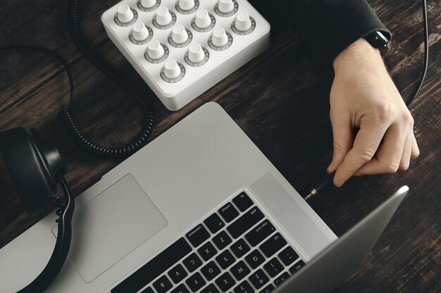 Cerrar los enchufes de mano en el cable de los auriculares en el puerto de música jack estéreo en el portátil retina