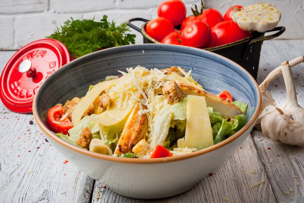 Cerrar ensalada de pollo en un tazón con ajo y tomates frescos