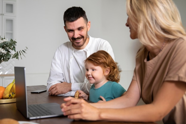 Foto gratuita cerrar familia en casa con laptop