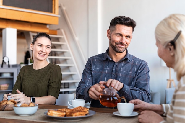 Foto gratuita cerrar familia feliz en la mesa