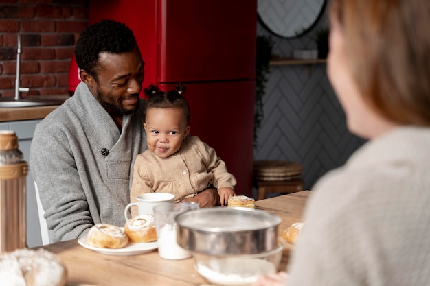 Foto gratuita cerrar feliz padre sosteniendo a los niños en la mesa