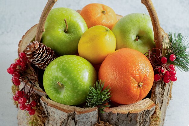 Cerrar foto de canasta de madera llena de diferentes frutas.