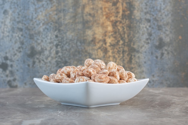 Foto gratuita cerrar foto de caramelos de caramelo en un tazón blanco.