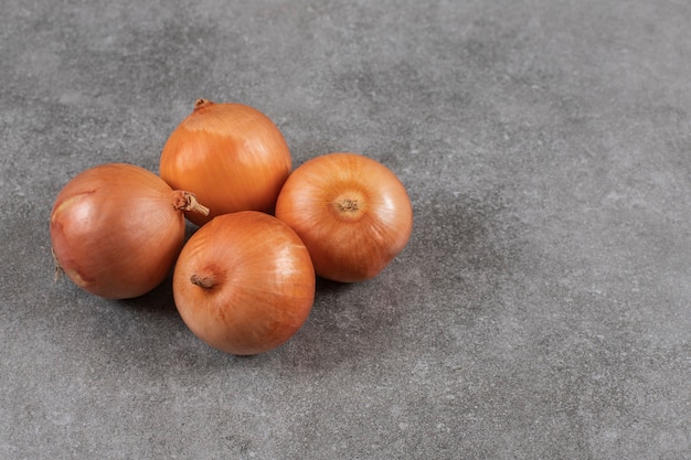 Foto gratuita cerrar foto de cebollas maduras en mesa gris.