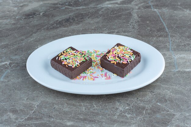 Cerrar foto de obleas de chocolate en plato de cerámica blanca.