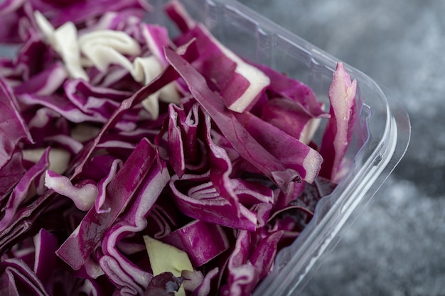 Foto gratuita cerrar foto de recipiente de plástico lleno de repollo morado picado. fotografía macro.