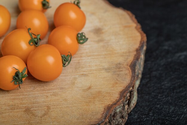 Cerrar fotos de tomates cherry crudos sobre tablero de madera. Foto de alta calidad