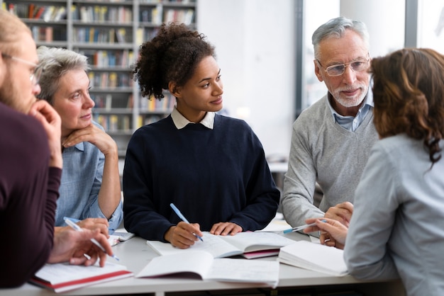 Foto gratuita cerrar gente estudiando juntos