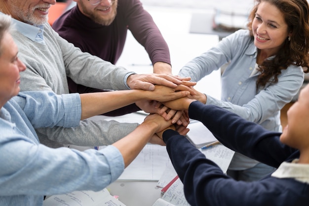 Cerrar gente feliz cogidos de la mano juntos