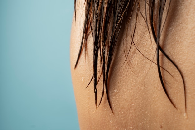 Cerrar gotas de agua sobre el cabello de la mujer