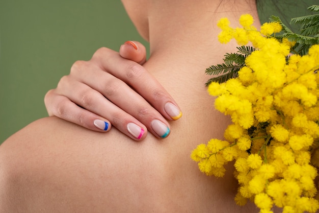 Foto gratuita cerrar hermosa manicura y flores amarillas