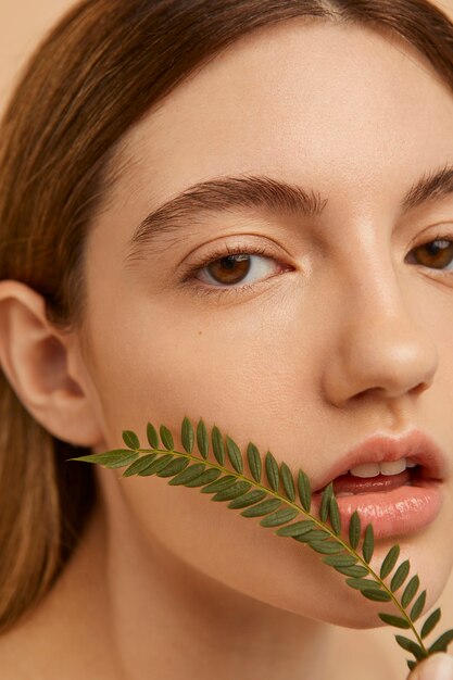 Cerrar hermosa mujer posando con planta