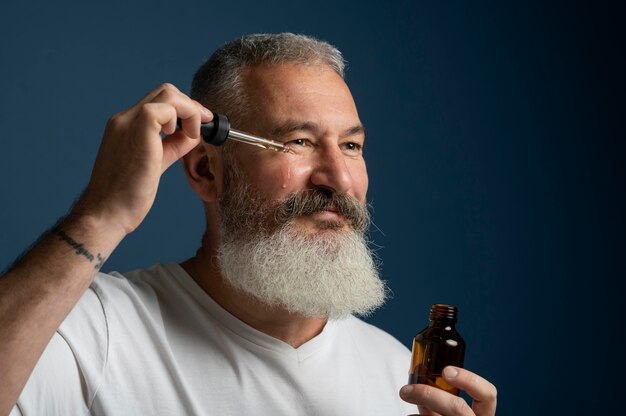 Cerrar hombre aplicando suero facial