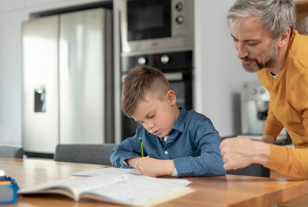 Cerrar hombre ayudando a niño con la tarea