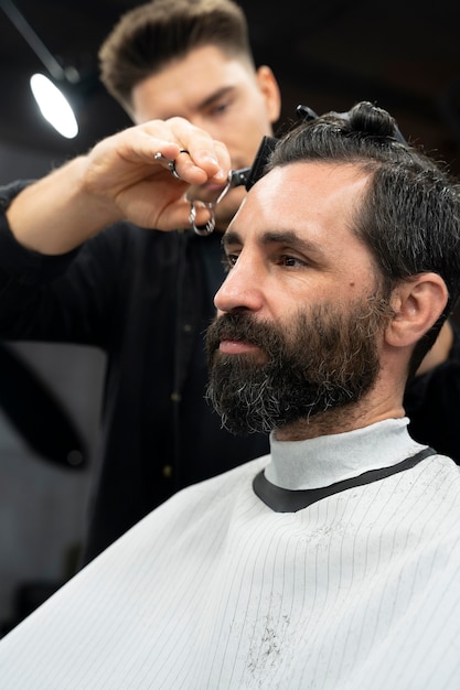 Cerrar hombre cortándose el pelo en el salón