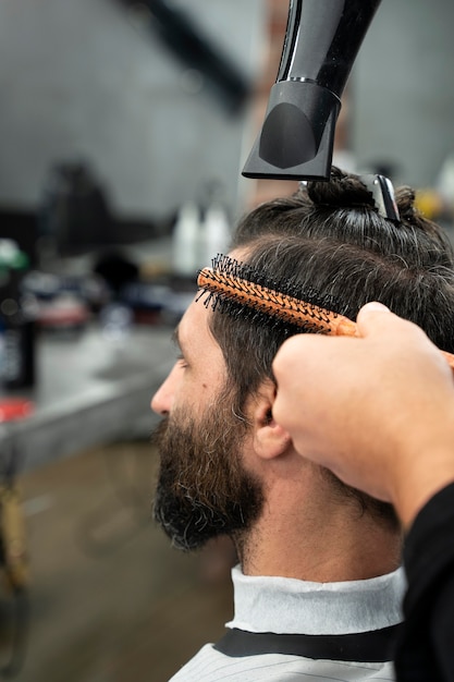 Foto gratuita cerrar hombre cortándose el pelo