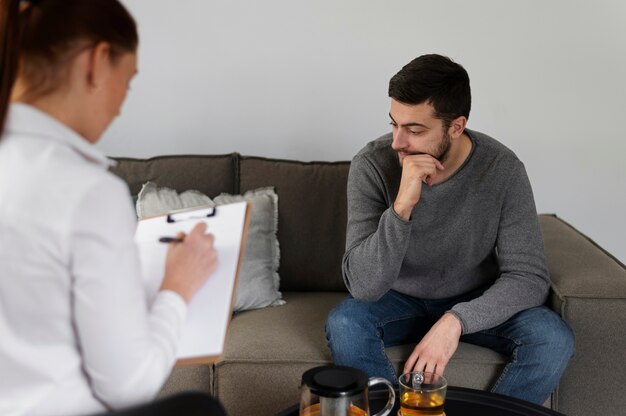 Cerrar hombre discutiendo con terapeuta