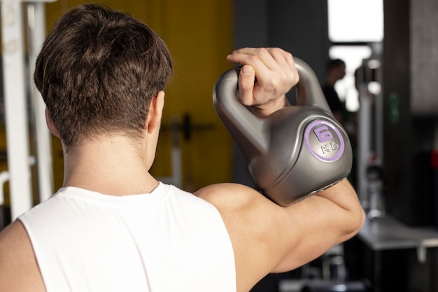 Cerrar hombre entrenando con pesas rusas