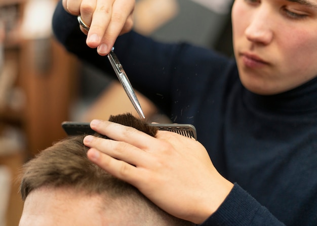 Cerrar hombre haciendo corte de pelo