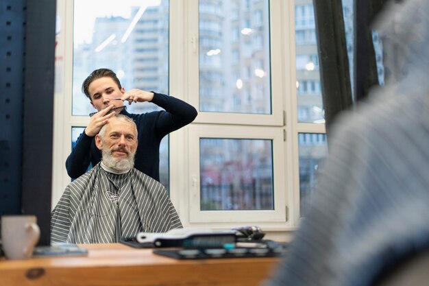 Cerrar hombre senior conseguir corte de pelo fresco