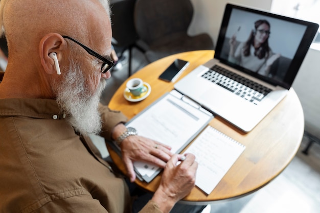 Foto gratuita cerrar hombre senior tomando notas