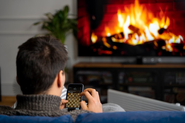 Foto gratuita cerrar hombre sentado con teléfono inteligente