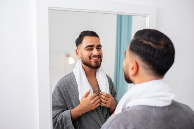 Foto gratuita cerrar hombre sonriente mirando en el espejo