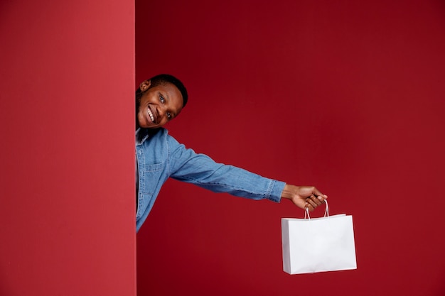 Cerrar hombre sonriente sosteniendo una bolsa de papel