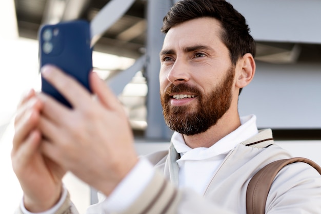 Cerrar el hombre sonriente sosteniendo el teléfono inteligente