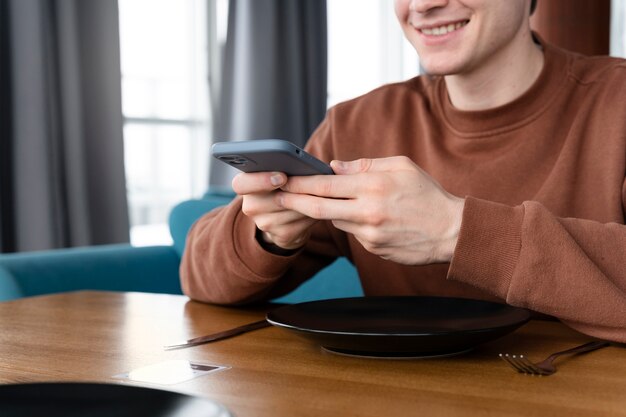 Cerrar el hombre sonriente sosteniendo el teléfono inteligente