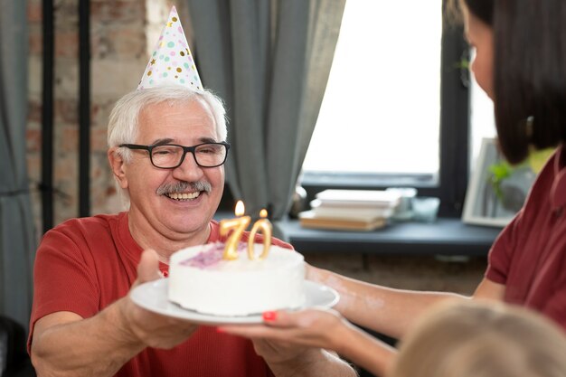Cerrar hombre sonriente sosteniendo la torta