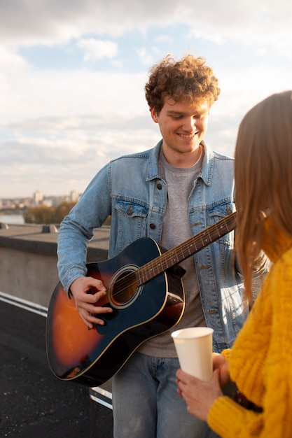 Cerrar hombre sonriente tocando la guitarra