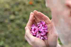 Foto gratuita cerrar hombre sosteniendo hermosas flores