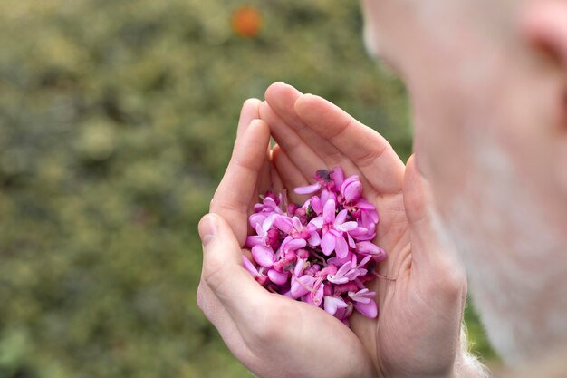 Cerrar hombre sosteniendo hermosas flores