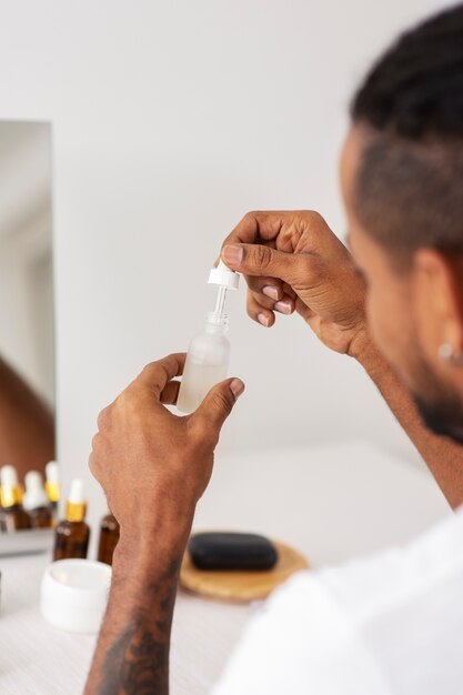 Cerrar hombre sujetando la botella de suero