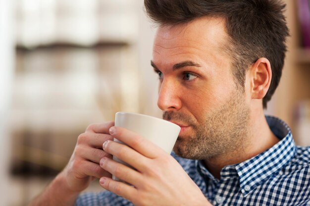 Cerrar hombre tomando café en casa