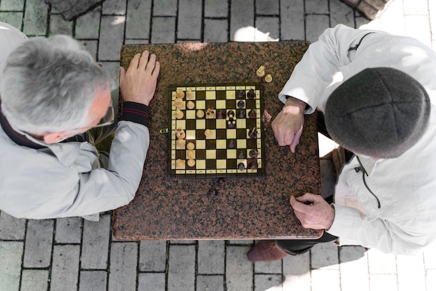 Foto gratuita cerrar hombres jugando al ajedrez juntos vista superior