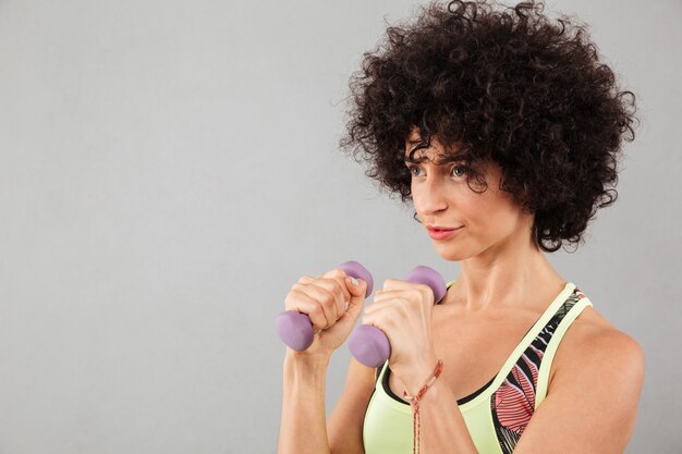 Cerrar imagen de mujer concentrada fitness rizado haciendo ejercicio