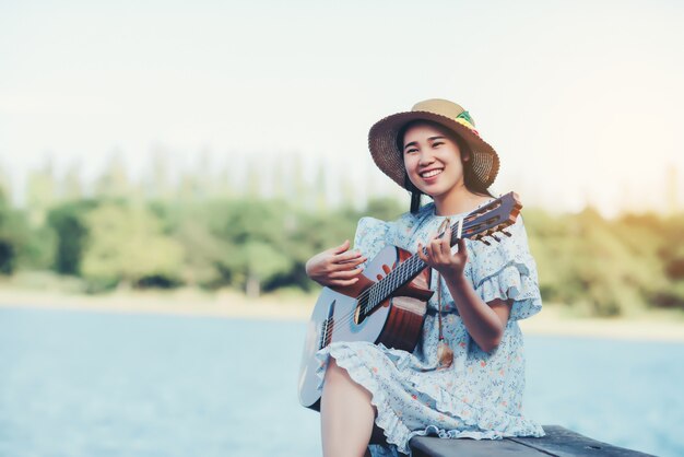 Cerrar imágenes de manos de mujer tocando guitarra acústica