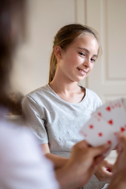 Cerrar madre y niña jugando a las cartas