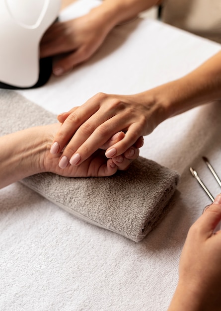 Cerrar manicurista sosteniendo la herramienta de uñas